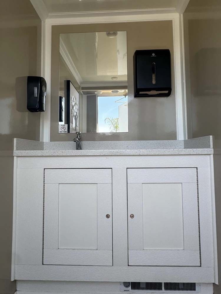 Restroom vanity with mirror, soap dispenser and paper towel dispenser